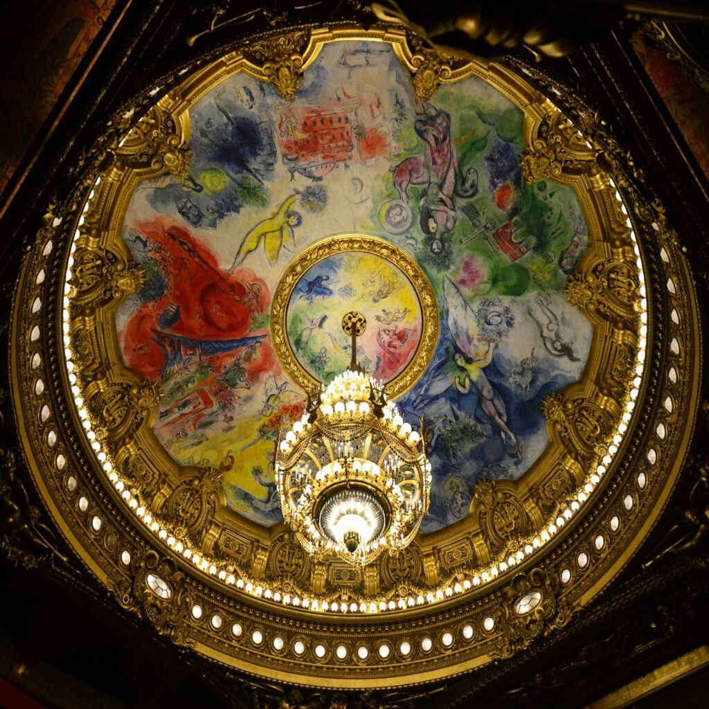the ceiling of a building with a fancy painting on it